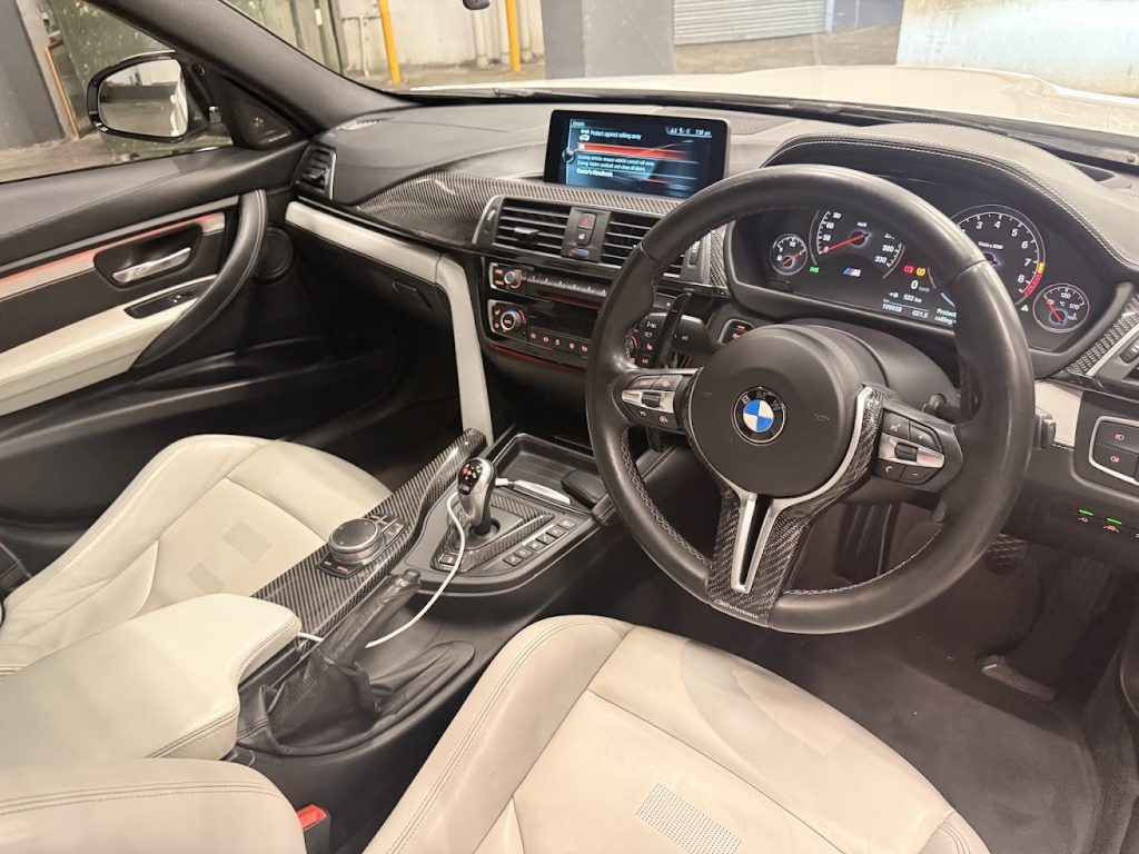 Dashboard of the white 2016 BMW M3 Competition F80, available for hire in Sydney