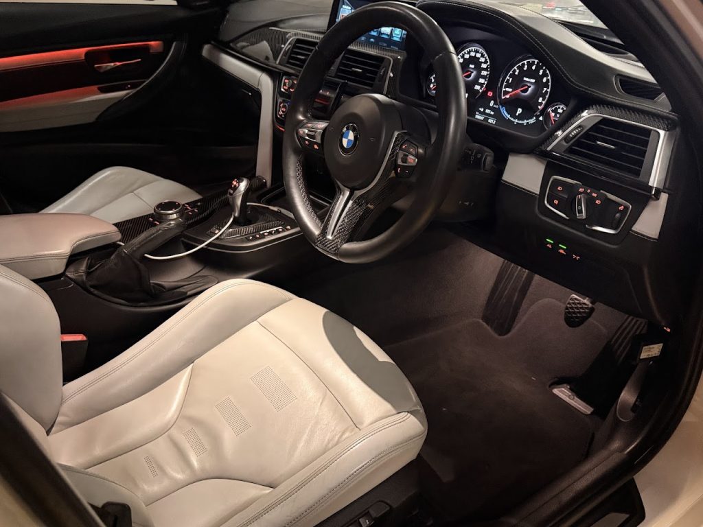 Dashboard of the white 2016 BMW M3 Competition F80, available for hire in Sydney