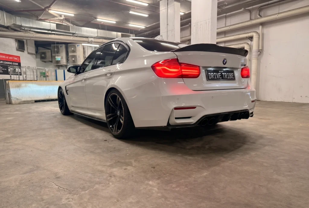 White 2016 BMW M3 Competition F80, rear three-quarter view, available for hire in Sydney