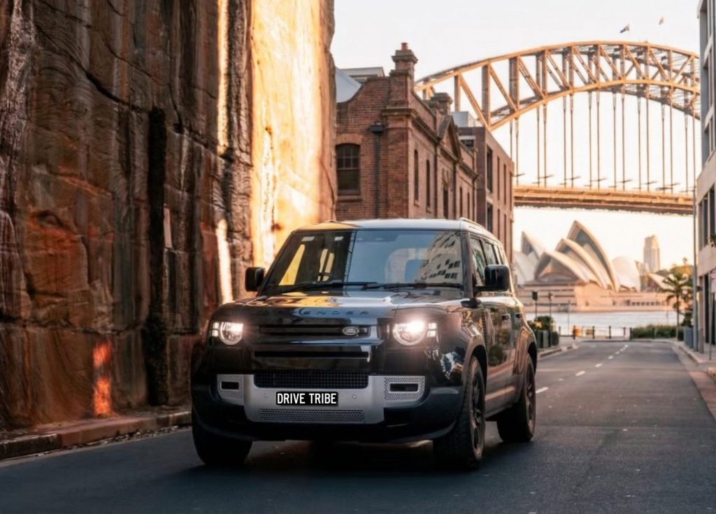 Grey 2023 Land Rover Defender, front three-quarter view, available for hire in Sydney