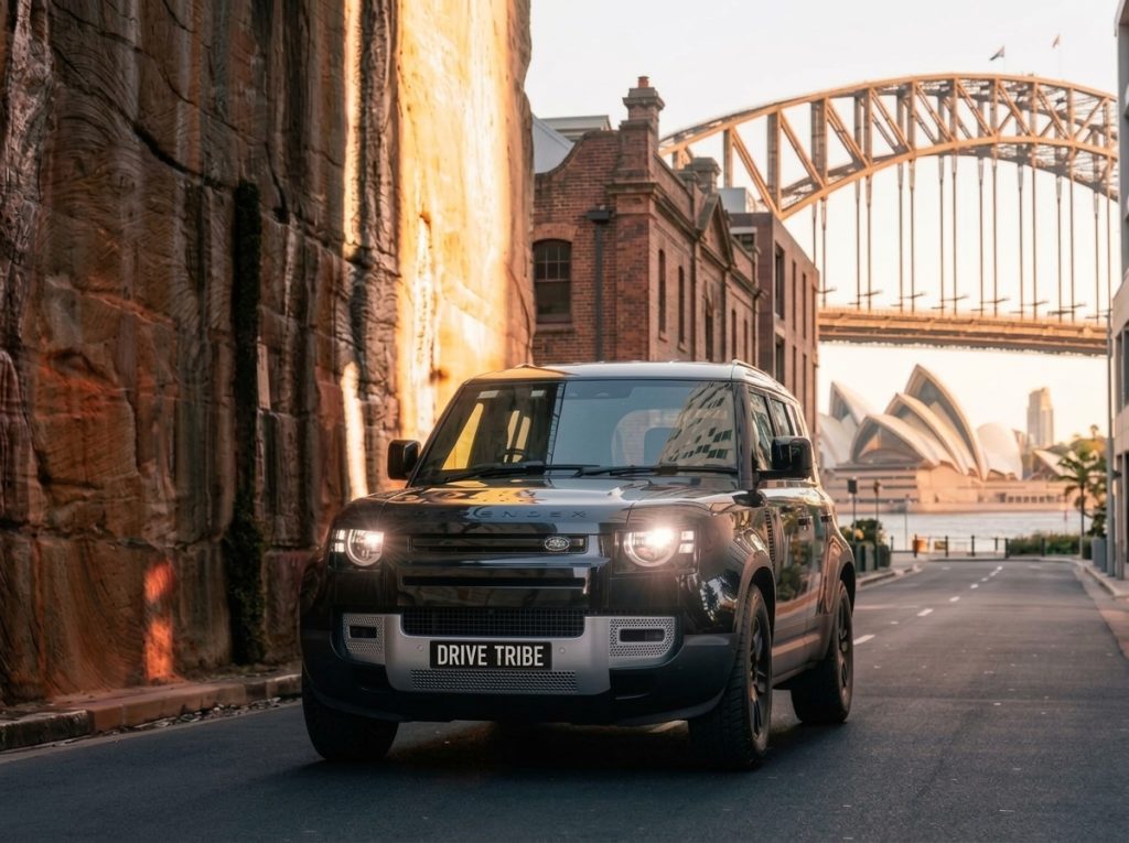 Grey 2023 Land Rover Defender, front three-quarter view, available for hire in Sydney